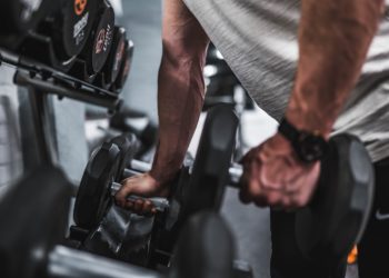Homme prenant poid en main dans le but de faire de la musculation