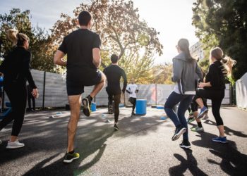 Personnes faisant du sport en groupe à l'extérieur avec un coach