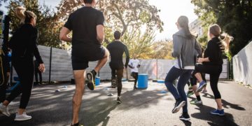 Personnes faisant du sport en groupe à l'extérieur avec un coach