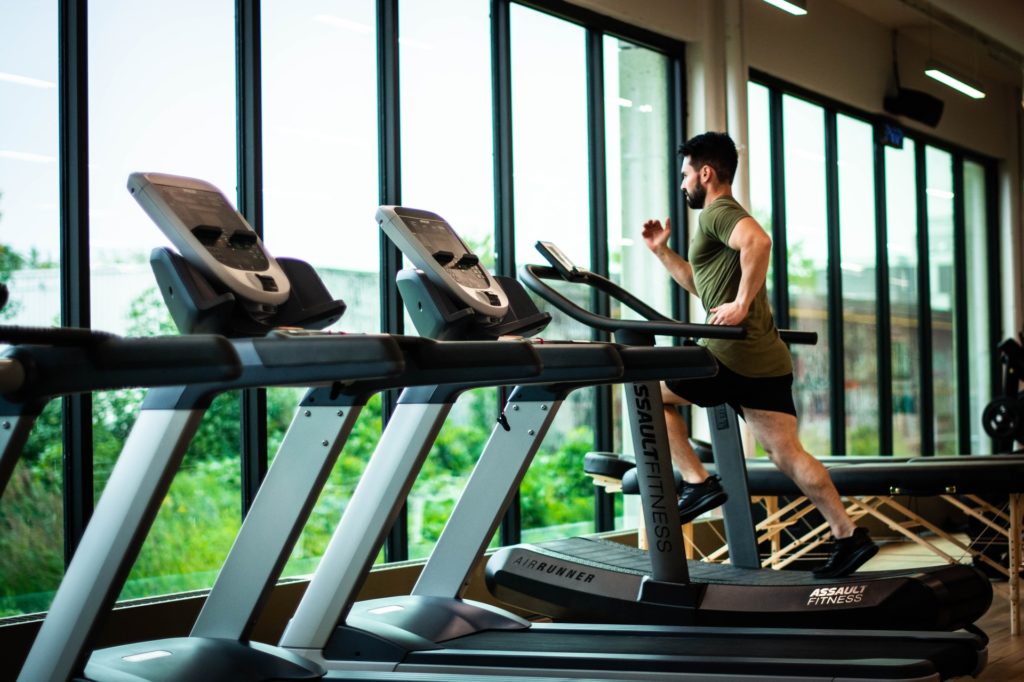 Personne courant sur un tapis de course dans une salle de sport