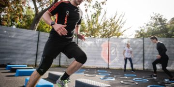 Monsieur qui fait du sport en extérieur à plusieurs