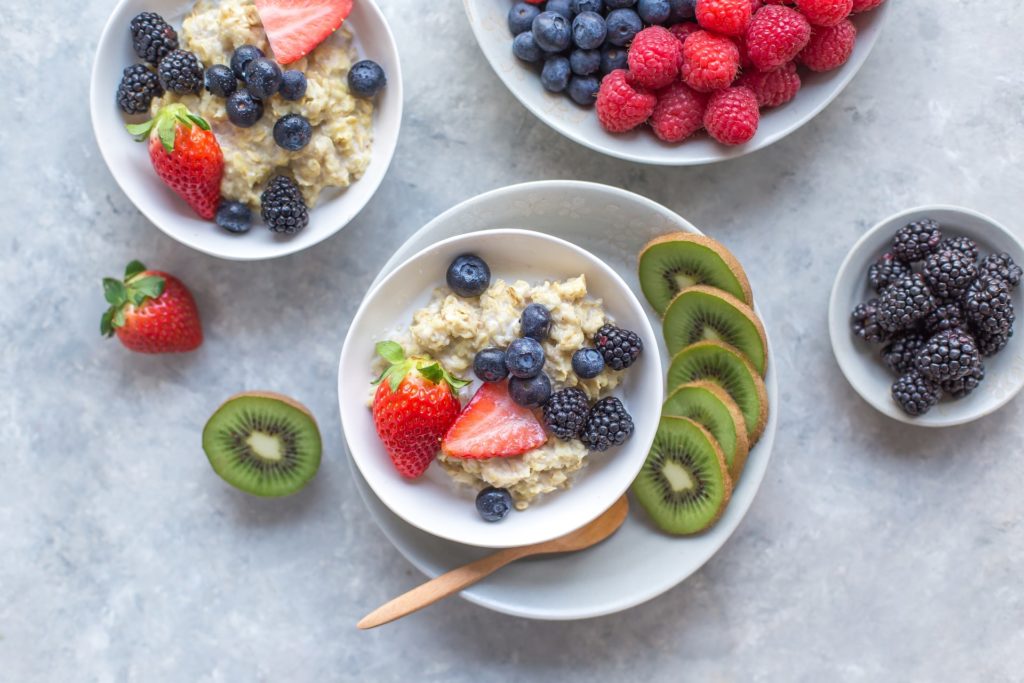 Bolle de flocons d'avoine, bannane, fraise et cerise avec des kiwis en accompagnent sur le côté