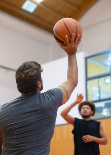 Deux personnes jouant au basketball en salle
