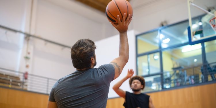 Deux personnes jouant au basketball en salle