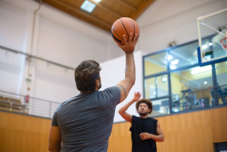 Deux personnes jouant au basketball en salle