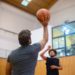 Deux personnes jouant au basketball en salle