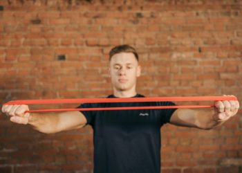 Personne tendant une bande élastique de musculation tendu devant lui