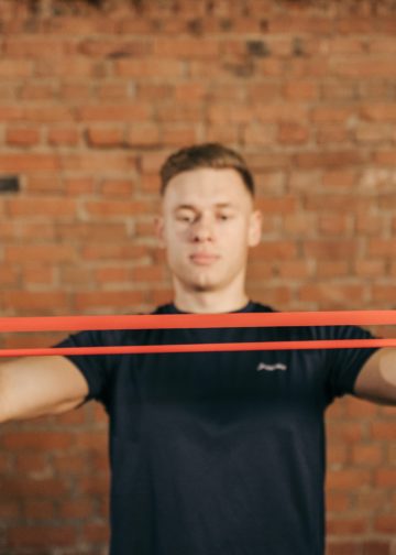 Personne tendant une bande élastique de musculation tendu devant lui