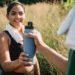 Quelqu'un qui donne une gourde à une femme qui semble faire du sport