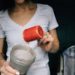 Femme qui remplit un shaker d'une poudre, probablement de la BCAA